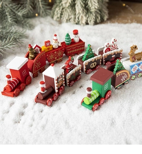 Three hand-painted wooden Christmas trains with snowmen and reindeer on faux snow background