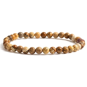 Macro detail of natural stone beaded bracelet showing earthy brown and grey textures