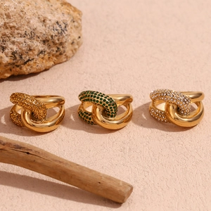 Detailed shot of link rings in gold finish featuring orange, green and white zircons