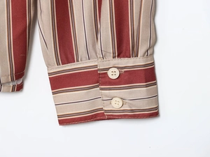 Détail des poignets réglables à double bouton sur une chemise en coton à rayures