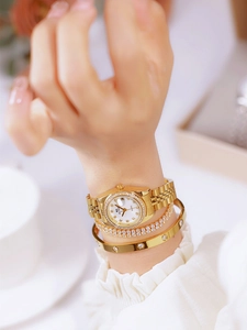 Close-up of gold-plated women's watch with crystal bezel and matching bracelets