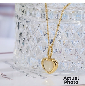 Macro shot of an elegant heart-shaped mother of pearl pendant on a gold necklace