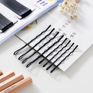 Set of wavy black metal hair pins with ball tips on card for secure hairstyling