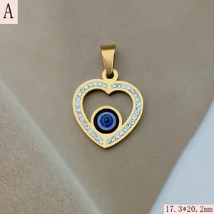 Detailed macro of gold heart-shaped evil eye pendant with crystal inlay and 17.3*20.2mm size