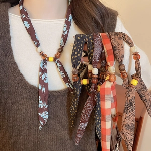 Detail of bohemian silk fabric necklaces with resin beads in multiple floral patterns
