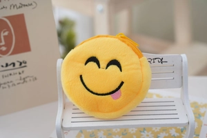 Detailed close-up of a yellow plush emoji coin purse with smiley face on a mini bench