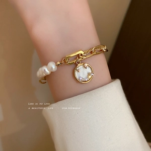 Gold chain and freshwater pearl bracelet with a sparkling zircon smiley face charm