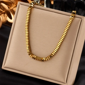 Golden faceted beaded necklace elegantly displayed on a premium jewelry stand