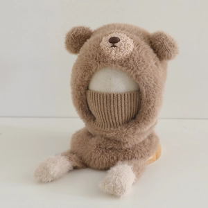 Détail du bonnet d'hiver en peluche ours avec masque intégré et texture douce marron