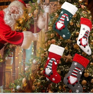 Détail de quatre chaussettes de Noël en tricot avec gnomes et flocons sur fond décoré