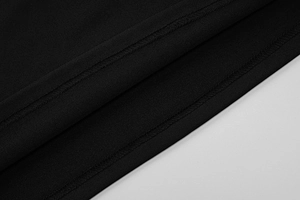 Detailed close-up of premium black fabric texture and professional stitching on dress hem