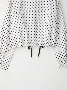 Détail de l'ourlet de la veste à pois avec taille élastique et cordons de serrage noirs
