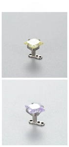 Macro detail of 6mm square zircon microdermal piercings in yellow and purple finish