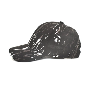 Detail view of black baseball cap with white fluid graffiti print and curved brim style