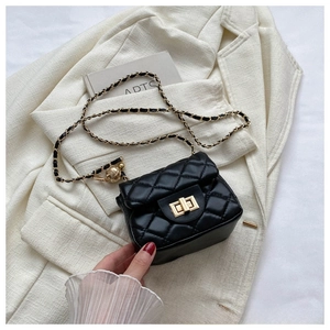 Detail of black quilted leather texture with gold-tone hardware clasp and chain strap