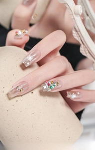 Macro detail of Christmas nail art kit with rhinestones, metal stars and white snowflakes