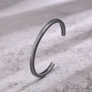 Detailed view of silver open cuff bracelet featuring complex vintage braided textures