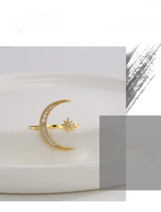 Detailed macro view of gold star and crescent moon ring with sparkling cubic zirconia