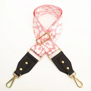 Detail of pink and white leopard print bag strap with brown leather and gold hardware