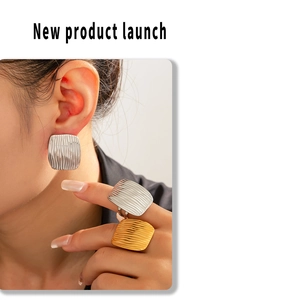 Detail shot of geometric square texture earrings and rings in gold and silver finish