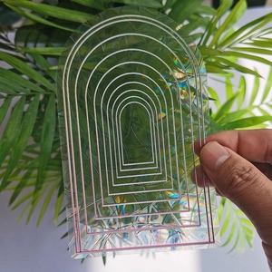 Holographic arch suncatcher sticker with rainbow prism effect on garden background