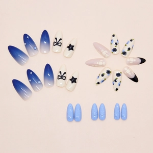 Detail van blauwe gradiënt kunstnagels met sterbedels en 3D-strikaccenten