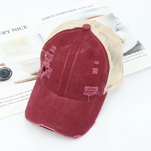Detail van vintage honkbalpet met ademend mesh en distressed bordeauxrode stof