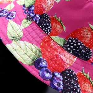 Close-up of strawberry print on vibrant rose red twill fabric reversible sun bucket hat