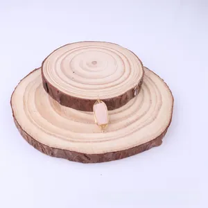 Detail of handmade wire wrapped pink natural stone pendant on wooden display
