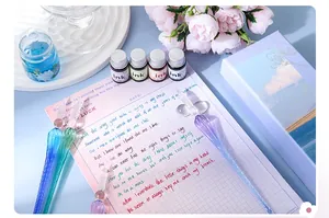 Detail of gradient glass dip pen set with ink bottles and notebook in a gift box