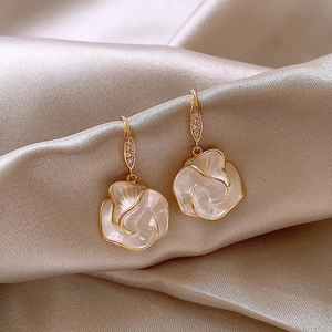 Elegant white camellia flower drop earrings with gold finish and sparkling zircons