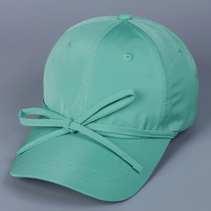 Detail showing mint green satin baseball cap with a decorative matching bow on the brim