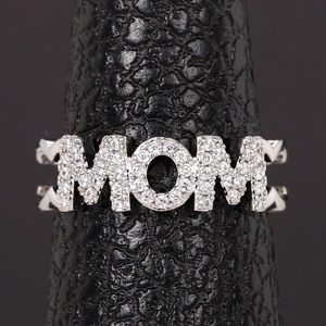 Macro shot of silver MOM letter ring with pavé sparkling crystals on a black stand