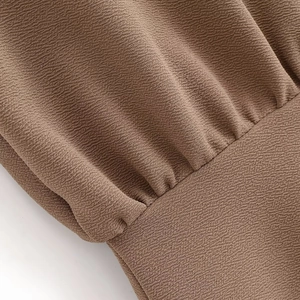 Detailed macro view of the brown crepe fabric texture and pleated stitching craftsmanship