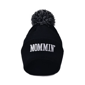 Black ribbed knit beanie with MOMMIN embroidery and a large mixed-color pom-pom