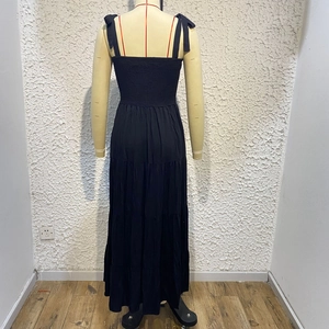 Detail of elegant black backless tiered maxi dress with smocked bodice and tie-straps