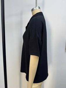 Close-up of black short sleeve blouse showing textured fabric and lapel details