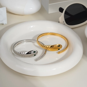 Snake shaped stainless steel bracelets in gold and silver with green gemstone eyes