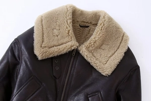 Détail de la veste en cuir marron foncé avec col épais en peau de mouton beige et fermeture éclair