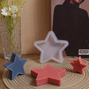 Stampi in silicone a forma di stella e candele profumate su sfondo in legno rustico