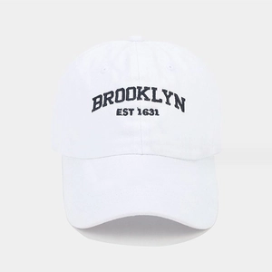 Close-up of black Brooklyn Est 1631 embroidery on white cotton twill baseball cap