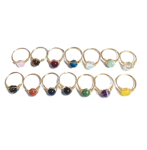 Flat lay detail showing a 14-piece set of handmade copper wire wrapped gemstone rings