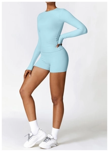 Détail de l'ensemble de yoga bleu clair avec haut à manches longues et short de sport ajusté