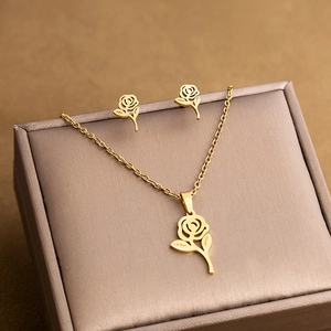 Detail of gold rose flower jewelry set with necklace and earrings on a luxury gift box