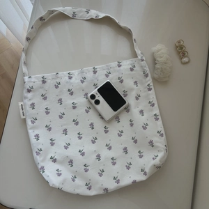 Floral cotton shoulder bag with lilac patterns and simple wish label on white fabric