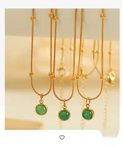 Detail of vintage green stone necklace with 18k gold plated chain and small gold beads