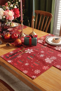 Close-up of festive red table runner and placemats with snowflake and ornament prints