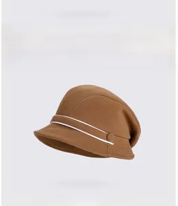 Detailed view of the brown knitted bucket hat texture and white parallel decorative stripes
