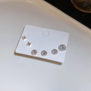 Detailed view of three pairs of silver cubic zirconia studs on a display card