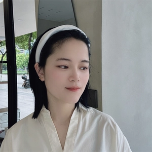 Cerchietto largo in tessuto bianco alla moda indossato da una modella, stile minimal
